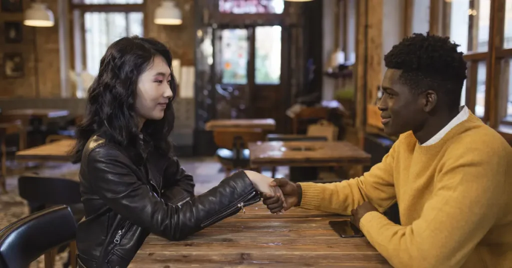 An image of a couple sitting across from each other in a cafe- highlighting the blog theme of modern dating guide.