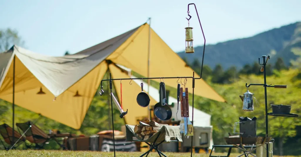 An image of some camping cooking essentials hanging on a string outside a camping tent.