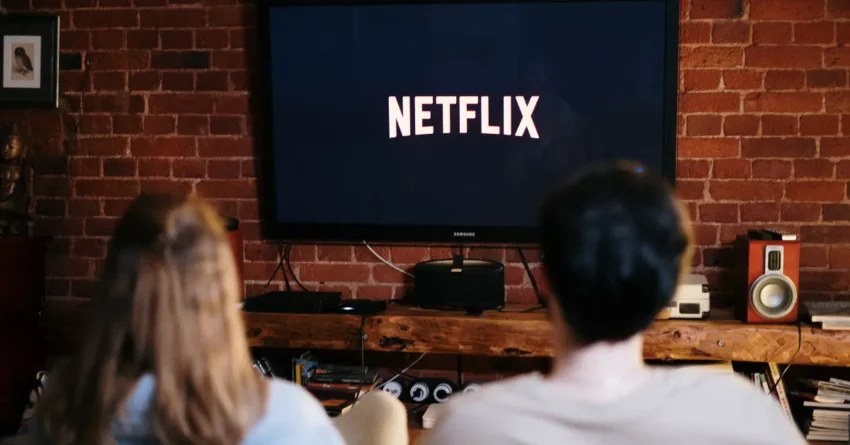 Two people, watching the best TV shows to watch on Netflix.