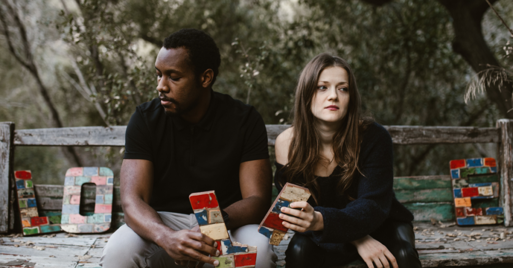 A couple, looking away from one another, after a fight, highlighting possible red flags in relationship. 